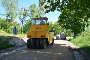 Układanie podbudowy pod drogę Jaśki – Dobki. Na fotografii samochody.