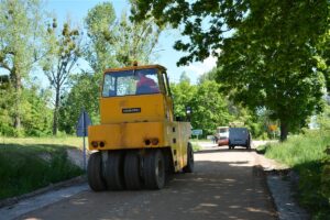 Układanie podbudowy pod drogę Jaśki – Dobki. Na fotografii samochody.