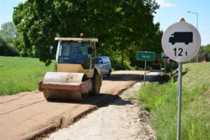 Układanie podbudowy pod drogę Jaśki – Dobki. Na fotografii samochody.