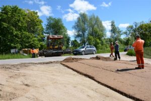 Układanie podbudowy pod drogę Jaśki – Dobki. Na fotografii samochody.