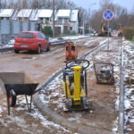 Ulica ze starą nawierzchnią bitumiczną. Budowa krawężników.