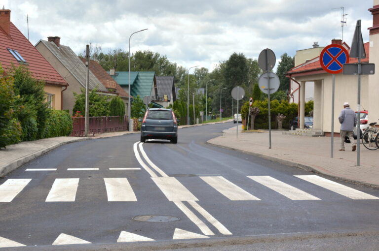 Nowa nawierzchnia bezpośrednio po ułożeniu. W środki widoczne są pasy i auto.