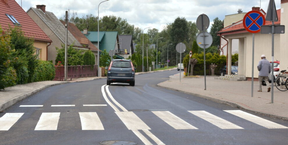 Nowa nawierzchnia bezpośrednio po ułożeniu. W środki widoczne są pasy i auto.